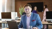 Nowe technologie w księgowości | Studia podyplomowe w Bydgoszczy | Uniwersytet WSB Merito Bydgoszcz: biznesmen przy biurku z laptopem i szklanką wody