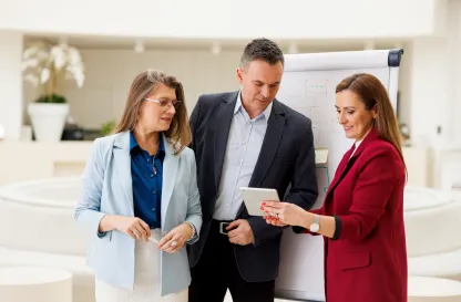 Aktualności | Uniwersytet WSB Merito Bydgoszcz: trzy osoby rozmawiające przy tablecie