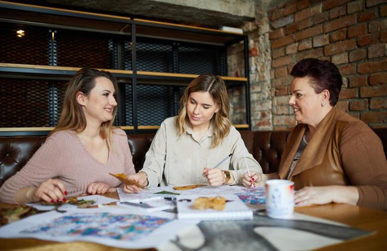 Nasze wartości | Uniwersytet WSB Merito Bydgoszcz: troje studentem w różnym wieku pracuje nad wspólnym projektem przy stole