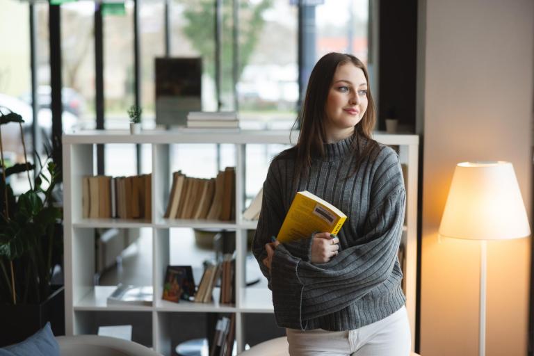 Studia II stopnia z podyplomowymi w Bydgoszczy | Uniwersytet WSB Merito Bydgoszcz: Główna grafika: Bydgoszcz-Studia II stopnia z podyplomowymi- Studentka w bibliotece