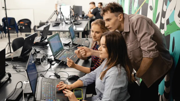 Spotkanie BRAVE AI Community w murach Uniwersytetu WSB Merito Bydgoszcz | Aktualności | Uniwersytet WSB Merito Bydgoszcz: dwójka studentów i wykładowca przed komputerem