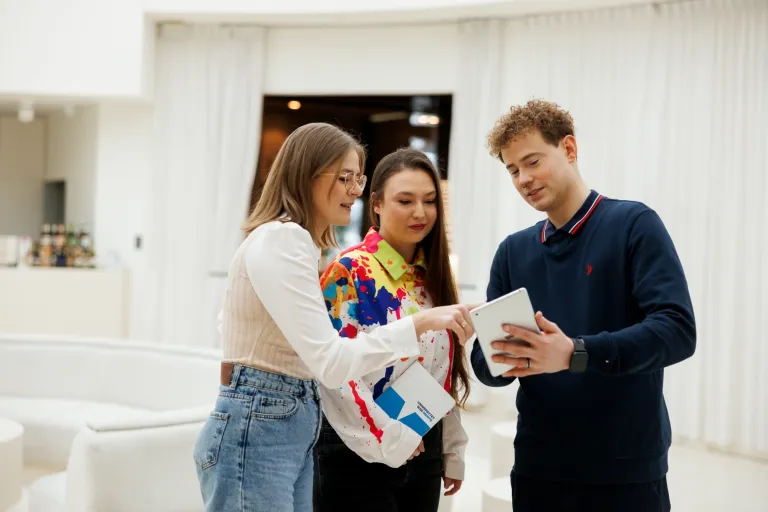 40. Czwartek Social Media już 12 marca! | Aktualności | Uniwersytet WSB Merito Bydgoszcz: trójka studentów przeglądająca tablet