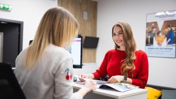 Kryminologia z elementami kryminalistyki | Studia I stopnia w Chorzowie | Uniwersytet WSB Merito Chorzów: studentka rozmawiająca z pracownikiem działu rekrutacji