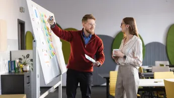 Prawo i zarządzanie | Studia I stopnia w Chorzowie | Uniwersytet WSB Merito Chorzów: studenci omawiają dane zapisane na tablicy