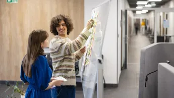 Strategie i techniki sprzedaży w modelu omnichannel | Studia I stopnia w Chorzowie | Uniwersytet WSB Merito Chorzów: dwójka studentów omawiająca dane na tablicy