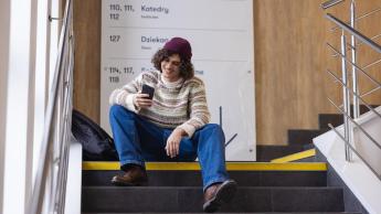 Informatyka | Studia II stopnia w Chorzowie | Uniwersytet WSB Merito Chorzów: student siedzący na korytarzu uczelni