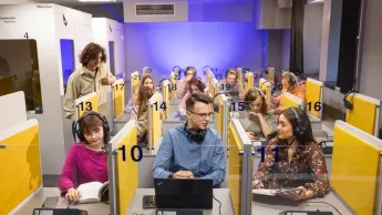 Język angielski w biznesie | Studia I stopnia w Chorzowie | Uniwersytet WSB Merito Chorzów: studenci siedzą w sali do tłumaczeń 