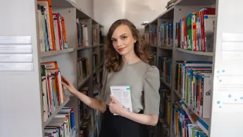 Dietetyka ANTI-AGING | Studia I stopnia w Chorzowie | Uniwersytet WSB Merito Chorzów: studentka przegląda książki w bibliotece