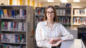 Wyniki wyszukiwania | Uniwersytet WSB Merito Chorzów: Studentka stojąca w bibliotece