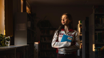 Wizaż i stylizacja | Studia I stopnia w Chorzowie | Uniwersytet WSB Merito Chorzów: Studentka stojąca w bibliotece