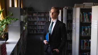 Finanse i rachunkowość | Studia II stopnia w Chorzowie | Uniwersytet WSB Merito Chorzów: Student stojący w bibliotece