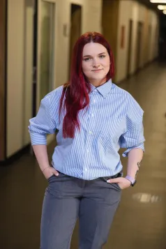 Dziekanat | Uniwersytet WSB Merito Chorzów: Studentka stojąca na korytarzu 