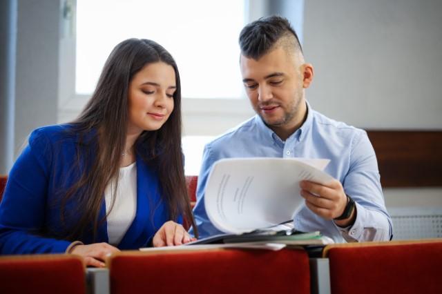 Szkolenia i kursy w Chorzowie | Uniwersytet WSB Merito Chorzów: studenci na auli omawiający swoje notatki