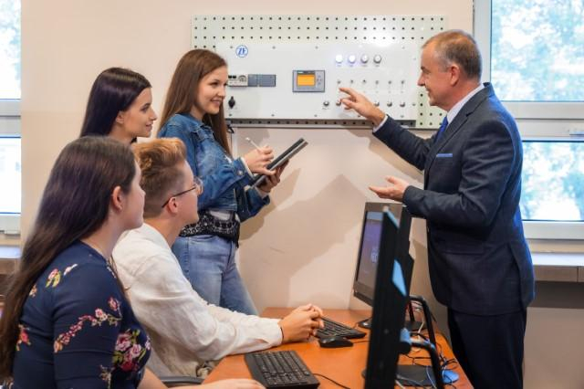 Logistyka | Studia II stopnia w Chorzowie | Uniwersytet WSB Merito Chorzów: studenci omawiający sprzęt logistyczny z wykładowcą