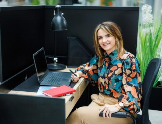 Pełnomocnik ds. dostępności | Uniwersytet WSB Merito Chorzów: studentka za biurkiem