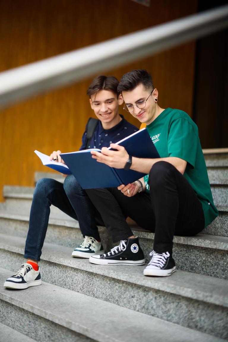 Studia I stopnia w Chorzowie | Uniwersytet WSB Merito Chorzów: Dwóch studentów na schodach z książką