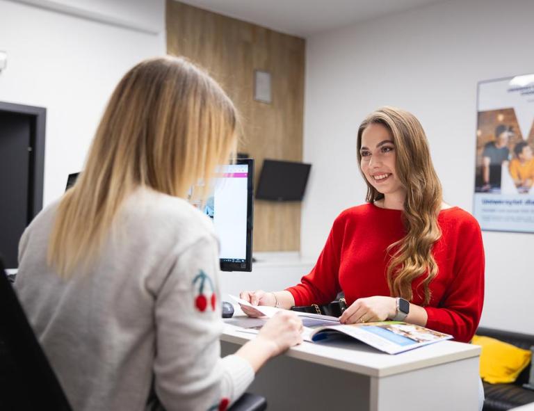 Nasze wartości | Uniwersytet WSB Merito Chorzów: studentka rozmawiająca z pracownikiem działu rekrutacji