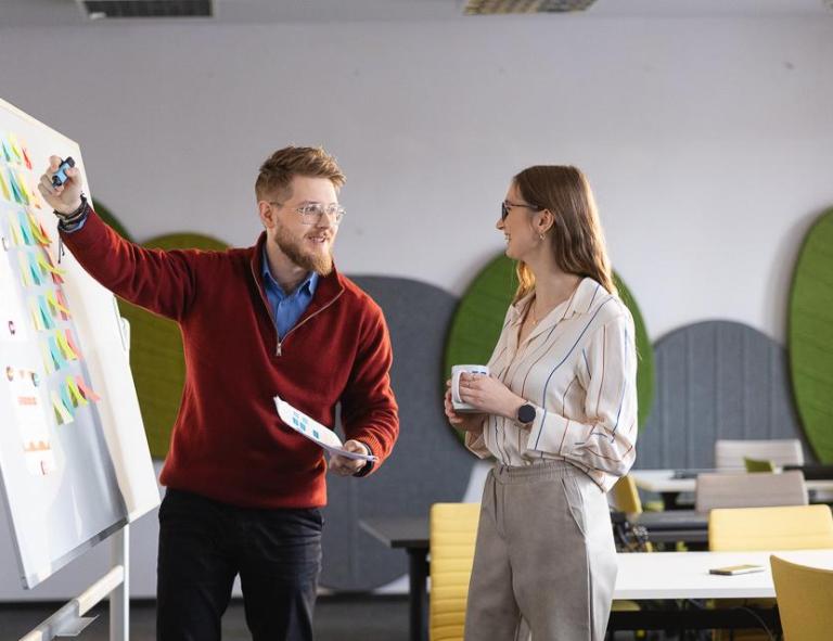 Przyznanie akredytacji | Uniwersytet WSB Merito Chorzów: studenci omawiają dane zapisane na tablicy