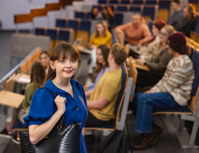 Rankingi i akredytacje | Uniwersytet WSB Merito Chorzów: studentka stojąca na auli wykładowej