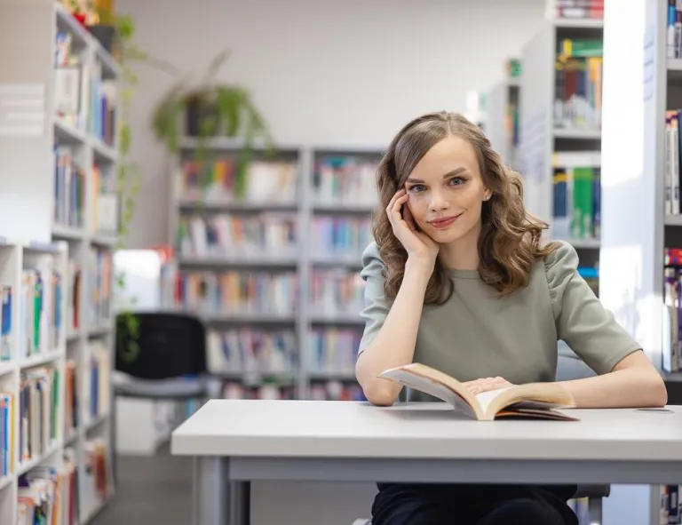 Inteligentne systemy logistyczne | Studia I stopnia w Chorzowie | Uniwersytet WSB Merito Chorzów: studentka siedząca i czytająca książkę w bibliotece