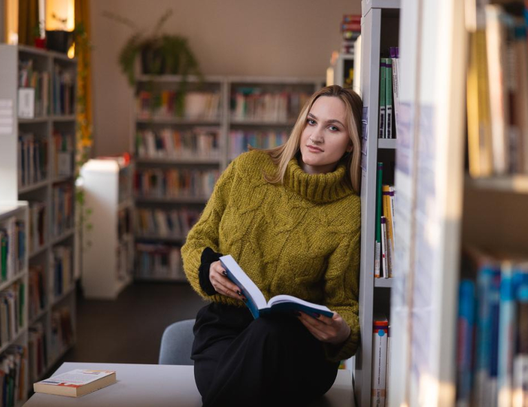 Logistyka | Studia I stopnia w Chorzowie | Uniwersytet WSB Merito Chorzów: studentka przeglądająca książki w bibliotece 