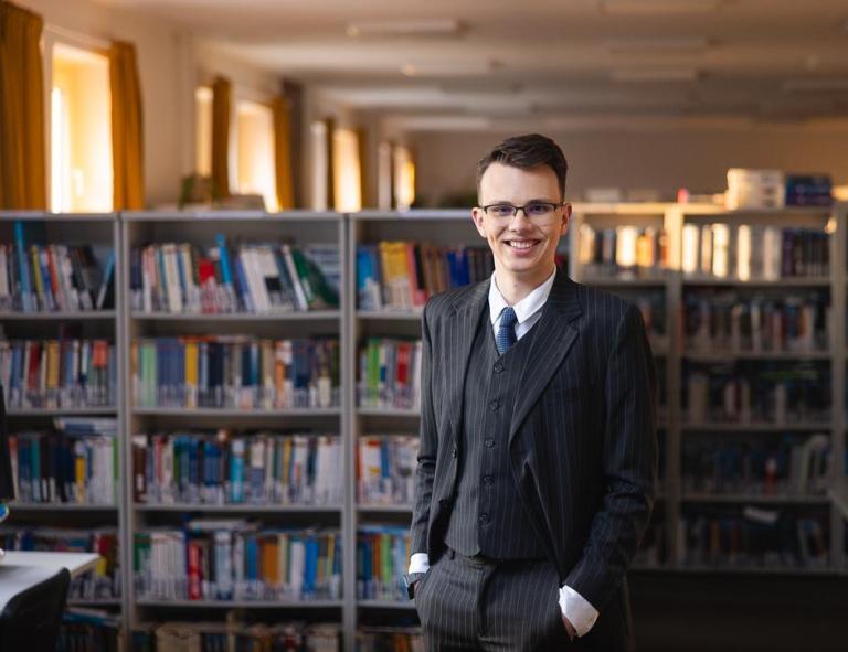 Zarządzanie przedsiębiorstwem | Studia I stopnia w Chorzowie | Uniwersytet WSB Merito Chorzów: Student stojący w bibliotece