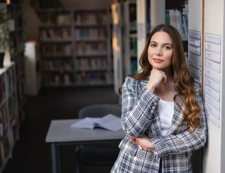 Kryminologia z elementami kryminalistyki | Studia I stopnia w Chorzowie | Uniwersytet WSB Merito Chorzów: Studentka stojąca w bibliotece 