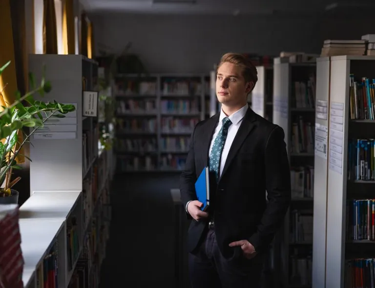 Zarządzanie w administracji publicznej | Studia I stopnia w Chorzowie | Uniwersytet WSB Merito Chorzów: Student stojący w bibliotece