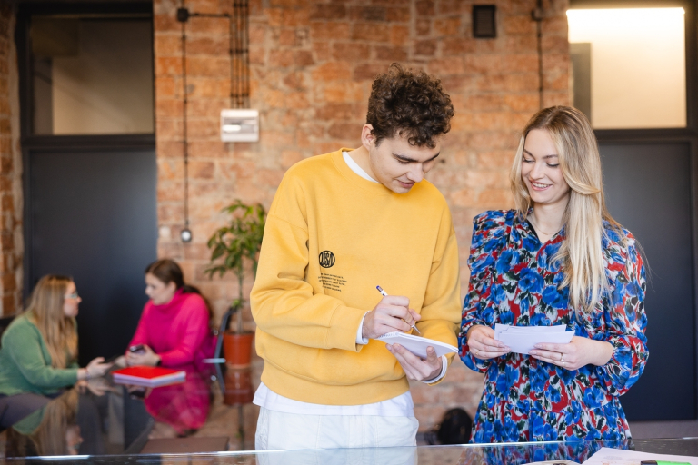 Nasze wartości | Uniwersytet WSB Merito Chorzów: Student i studentka na uczelni omawiają notatki z zajęć