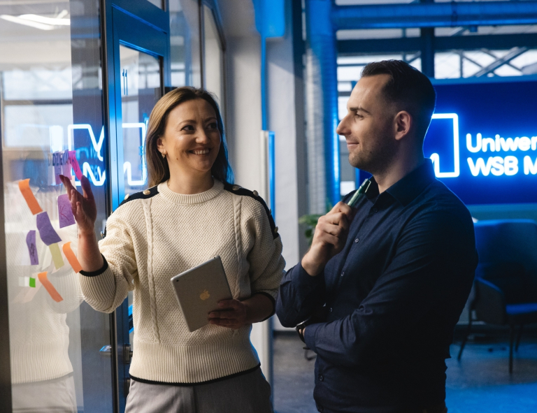 Kontynuuj studia | Uniwersytet WSB Merito Chorzów: Studenci rozmawiają na korytarzu