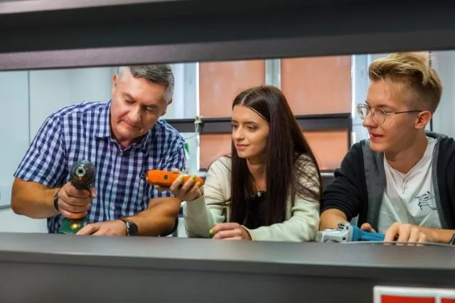 Logistyka | Uniwersytet WSB Merito Chorzów: studenci omawiający wykorzystanie sprzętu w sali