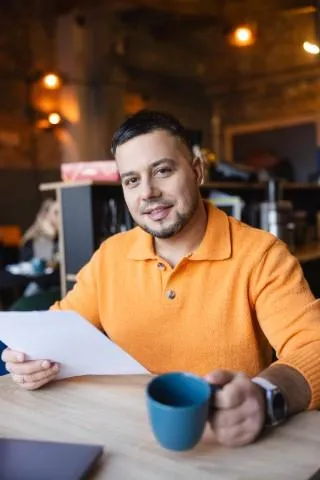 Finanse przedsiębiorstw i podatki z akredytacją ACCA | Studia I stopnia w Chorzowie | Uniwersytet WSB Merito Chorzów: student z kawą i notatkami