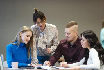 Strona główna | WSB Merito Bydgoszcz University: 4 studentów WSB Merito w Bydgoszczy siedzi przy stole i pracuje nad projektem