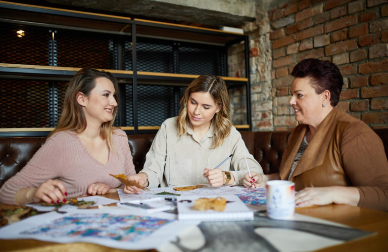 Our values | WSB Merito Bydgoszcz University: troje studentem w różnym wieku pracuje nad wspólnym projektem przy stole