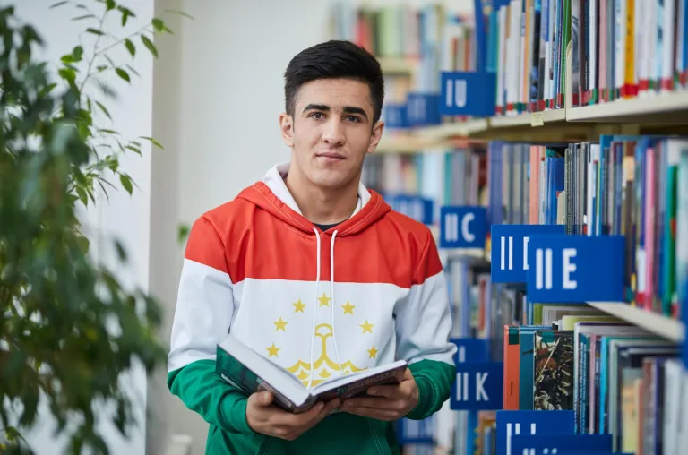 Library | WSB Merito Bydgoszcz University: student przegląda książkę w bibliotece Uniwersytetu WSB Merito Bydgoszcz