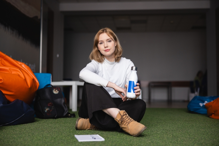 Student Council | WSB Merito Bydgoszcz University: Dziewczyna w strefie studenta na uczelni trzyma bidon w ręce