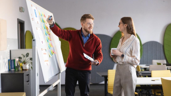 English for Business Purposes, studia I stopnia, licencjackie i inżynierskie: studenci omawiają dane zapisane na tablicy