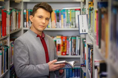 Library | WSB Merito University in Chorzów: student trzymający książkę