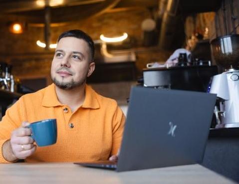 Digital university | WSB Merito University in Chorzów: student z kawą i laptopem