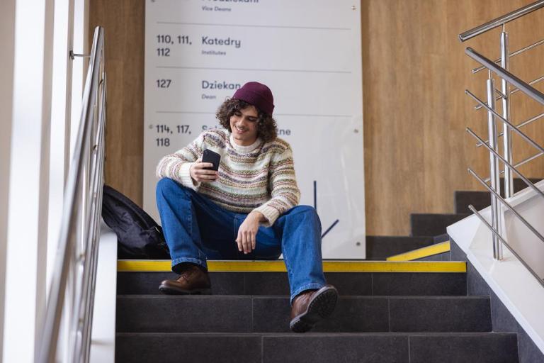 Digital university | WSB Merito University in Chorzów: student siedzący na korytarzu uczelni