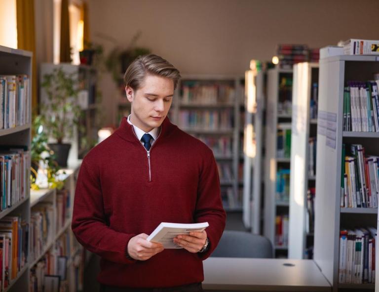 Business English with Spanish, studia I stopnia, licencjackie i inżynierskie: Student przeglądający książkę w bibliotece