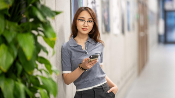 International Business Management | WSB Merito Gdańsk University: Studentka o azjatyckiej urodzie z komórką w ręku