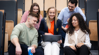 International Business | WSB Merito Gdańsk University: Studenci siedzą na auli w grupie przy laptopie