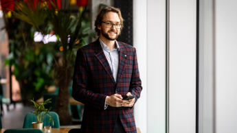 International Business | WSB Merito Gdańsk University: Zdjęcie biznesowe studenta w garniturze z komórką w rękach