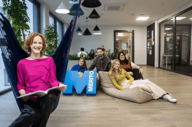 Search results | WSB Merito Gdańsk University: Studentka na hamaku siedzi z książką, za nią grupa studentów z sygnetem M