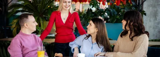 Search results | WSB Merito Gdańsk University: Studenci znajdujący się w kawiarni. Trzech z nich siedzi przy stoliku, a jedna osoba nad nimi stoi - rozmawiają