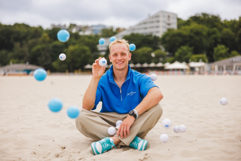 Search results | WSB Merito Gdańsk University: Grafika główna: samorząd studencki Gdańsk, student siedzi na plaży i trzyma piłeczkę z logo WSB Merito