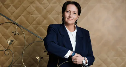 University authorities | WSB Merito Gdańsk University: Kobieta opierająca się o ramę schodów. Ma ona krótkie włosy i ubrana jest w garnitur