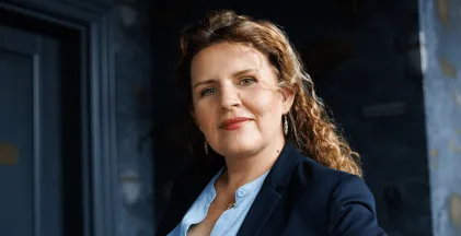 University authorities | WSB Merito Gdańsk University: Uśmiechająca się kobieta w lokach i niebieskiej koszuli