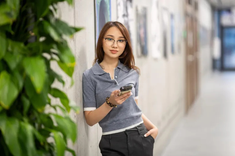 International Finance | WSB Merito Gdańsk University: Studentka o azjatyckiej urodzie z komórką w ręku